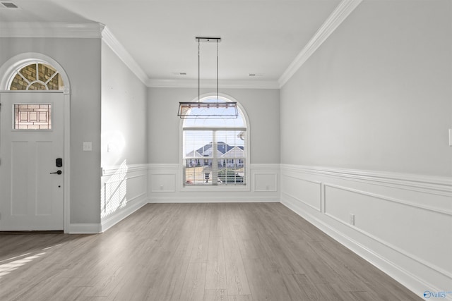 unfurnished dining area featuring hardwood / wood-style floors and crown molding