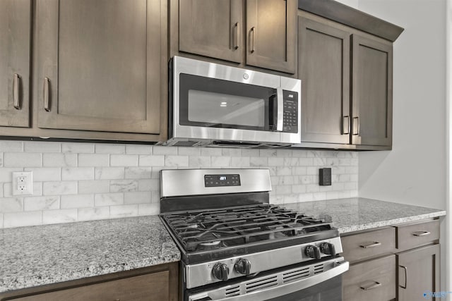 kitchen featuring tasteful backsplash, light stone countertops, and stainless steel appliances