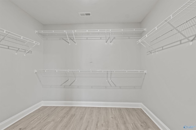 walk in closet with hardwood / wood-style flooring