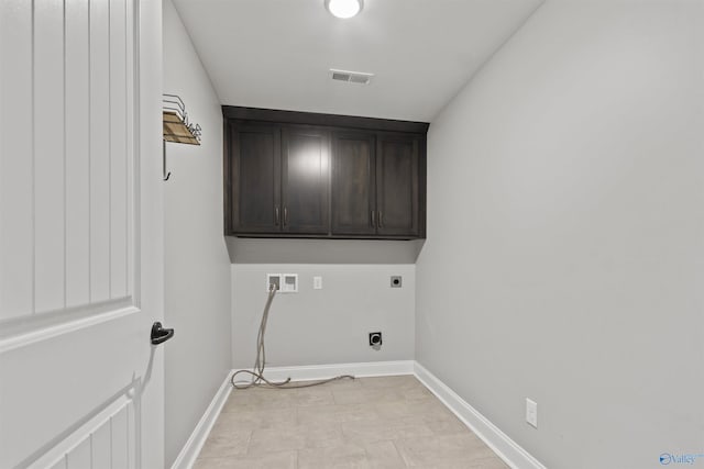 laundry area featuring hookup for an electric dryer, washer hookup, light tile patterned floors, and cabinets