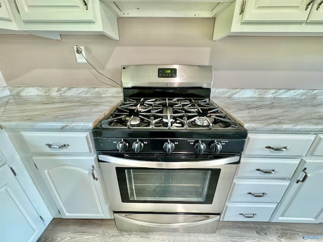 kitchen featuring white cabinetry and stainless steel gas range oven