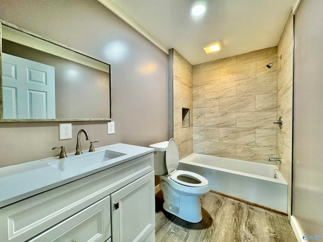 full bathroom featuring vanity, tiled shower / bath, wood-type flooring, and toilet