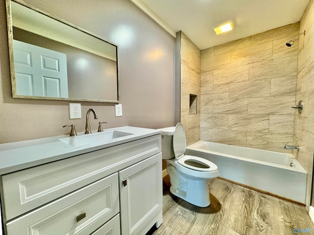 full bathroom featuring hardwood / wood-style floors, toilet, tiled shower / bath combo, and vanity