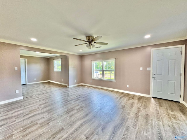 spare room featuring light hardwood / wood-style floors, ornamental molding, and ceiling fan