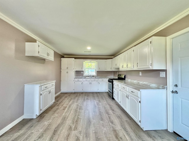 kitchen featuring white cabinetry, crown molding, light hardwood / wood-style flooring, stainless steel range with gas stovetop, and sink