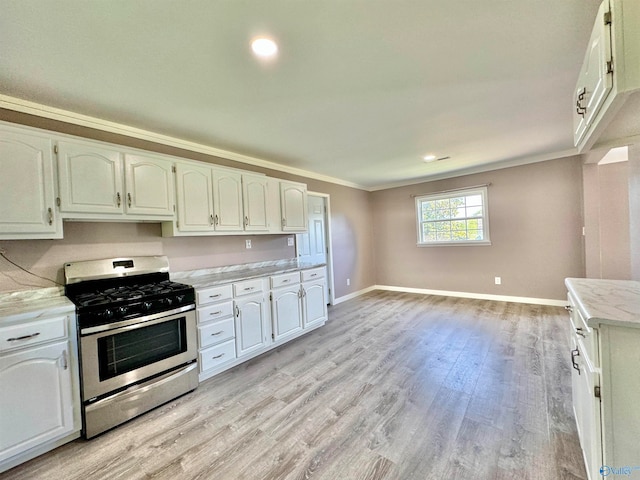 kitchen featuring stainless steel gas range, light wood-type flooring, white cabinets, and ornamental molding