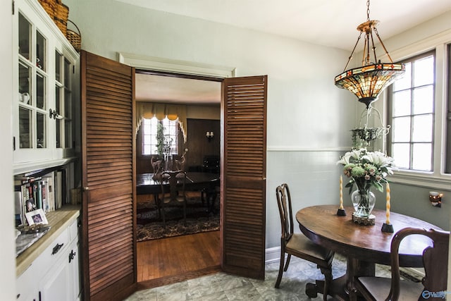 dining space with tile walls and a wainscoted wall