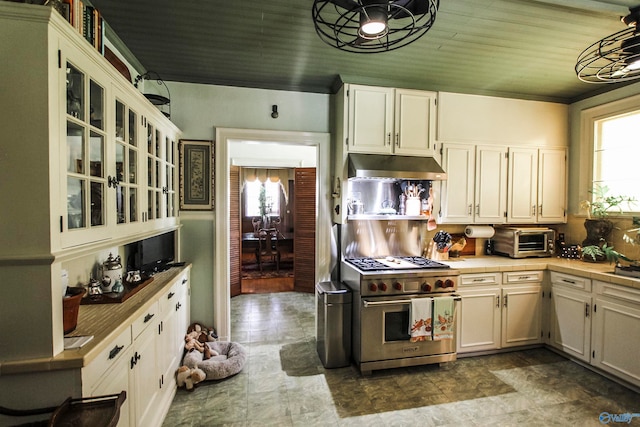 kitchen with tile patterned floors, white cabinets, designer stove, and wooden ceiling