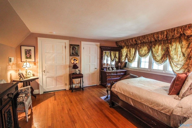 bedroom featuring lofted ceiling and hardwood / wood-style floors