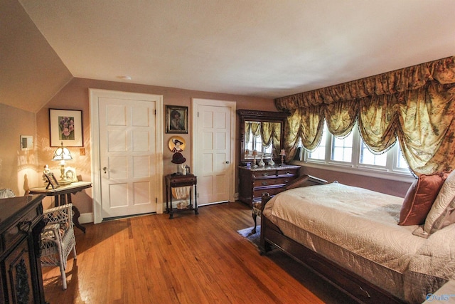 bedroom featuring baseboards and dark wood-style flooring