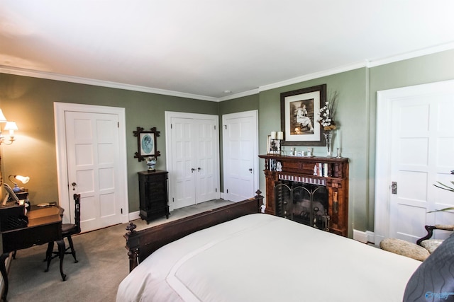 bedroom featuring ornamental molding, two closets, carpet floors, and a brick fireplace