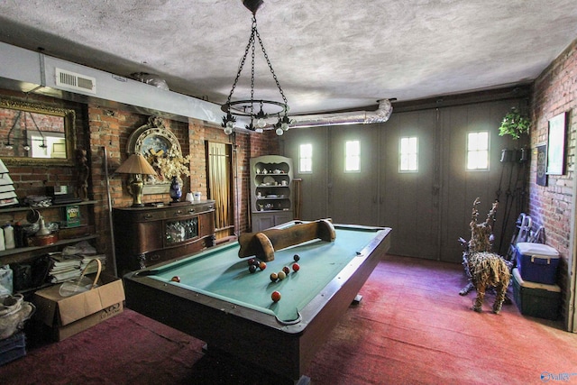 game room with pool table and brick wall