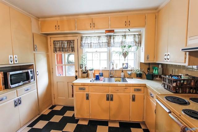 kitchen with sink, dark tile patterned floors, tasteful backsplash, tile countertops, and range with electric cooktop