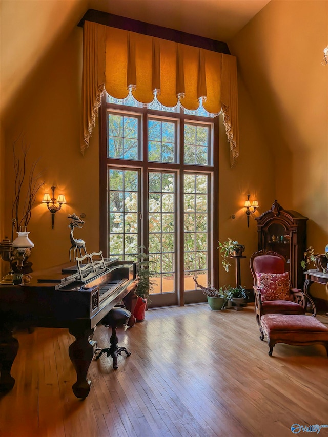 living area with vaulted ceiling and hardwood / wood-style floors