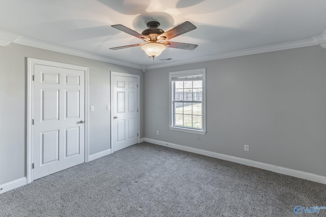 unfurnished bedroom featuring ceiling fan, carpet, and ornamental molding