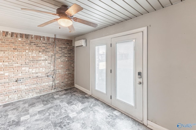 spare room featuring ceiling fan, a wall mounted AC, and brick wall