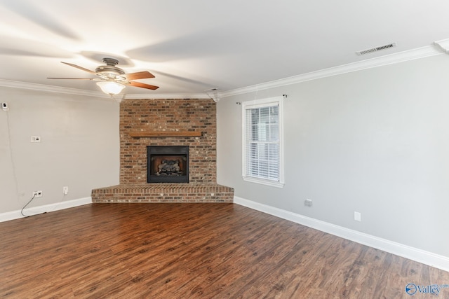 unfurnished living room featuring ceiling fan, dark hardwood / wood-style flooring, ornamental molding, and a brick fireplace