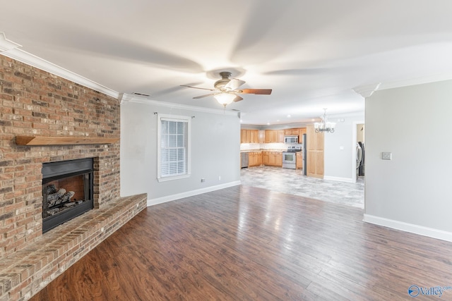 unfurnished living room featuring ceiling fan with notable chandelier, dark hardwood / wood-style floors, crown molding, and a fireplace