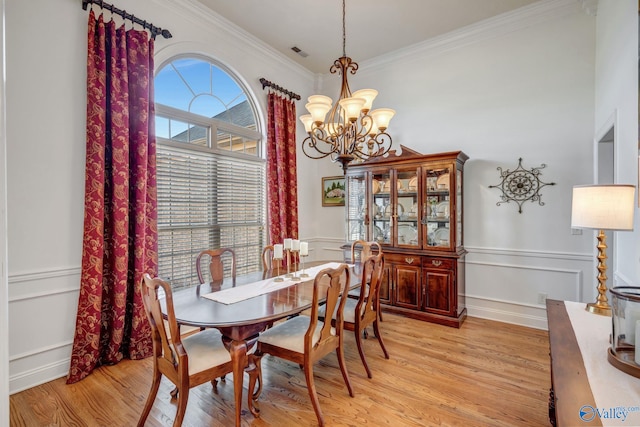 dining area with crown molding, light wood-style flooring, and a healthy amount of sunlight