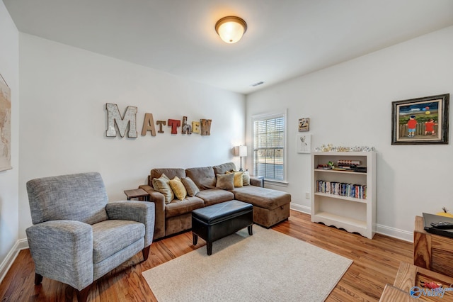 living area with visible vents, baseboards, and light wood-style flooring