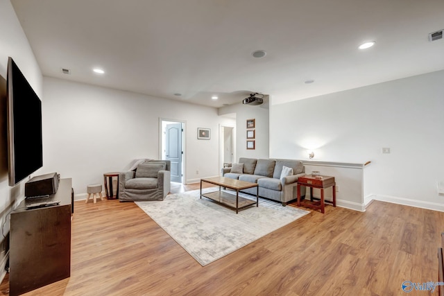 living room featuring recessed lighting, light wood-type flooring, and baseboards