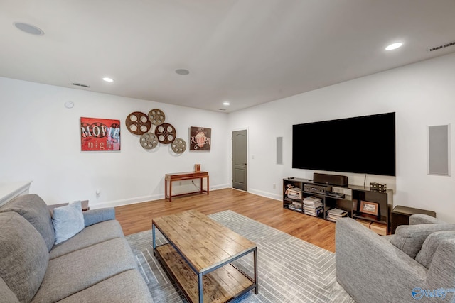 living room with wood finished floors, visible vents, and baseboards