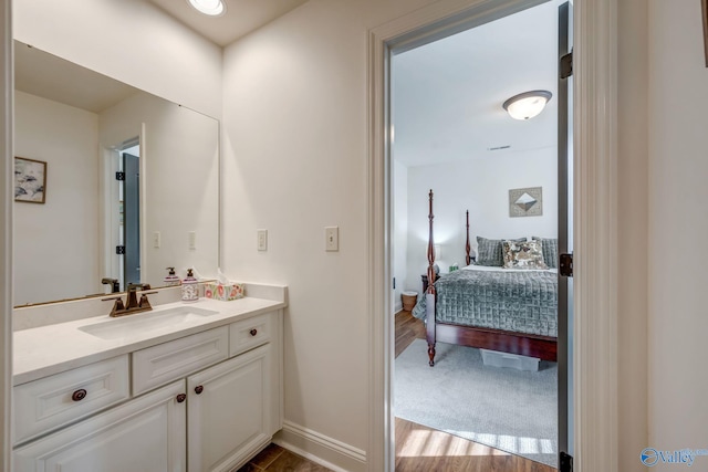 bathroom featuring vanity, baseboards, and wood finished floors