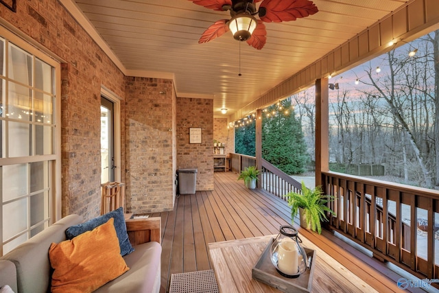 deck at dusk featuring ceiling fan