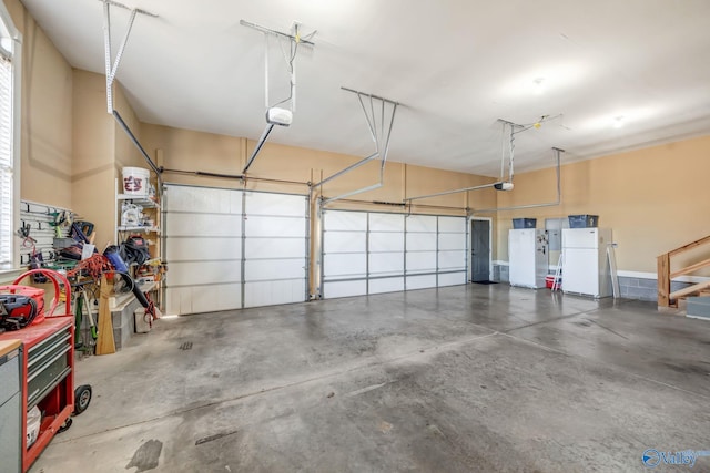 garage featuring a garage door opener and freestanding refrigerator