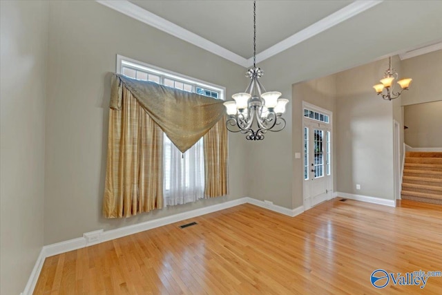 unfurnished dining area featuring hardwood / wood-style flooring, an inviting chandelier, and crown molding