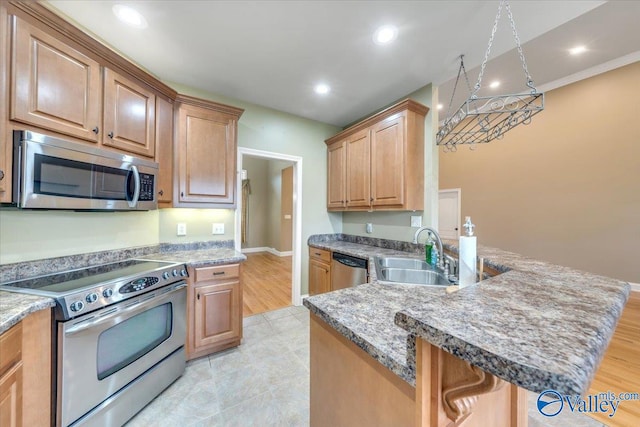 kitchen with light hardwood / wood-style floors, sink, a breakfast bar, and appliances with stainless steel finishes