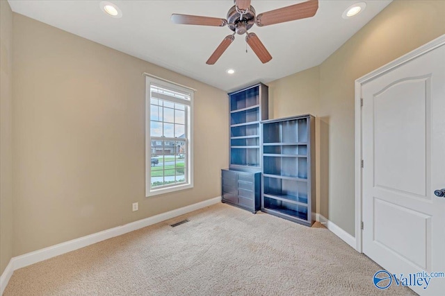 interior space featuring ceiling fan and light colored carpet