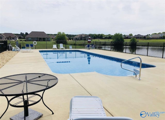 view of swimming pool with a patio and a water view