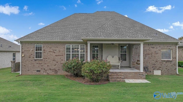 rear view of property featuring ceiling fan and a lawn