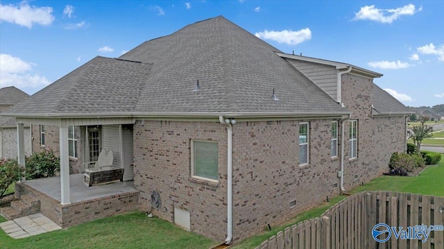 back of house featuring a lawn and a patio