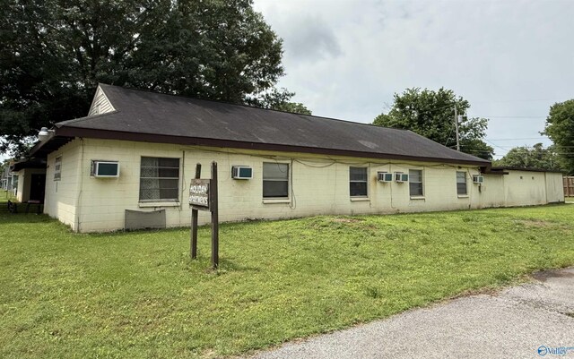 3004 SW Clopton St Unit 28, Huntsville, AL 35805 - back of house featuring concrete block siding, a lawn, and roof with shingles