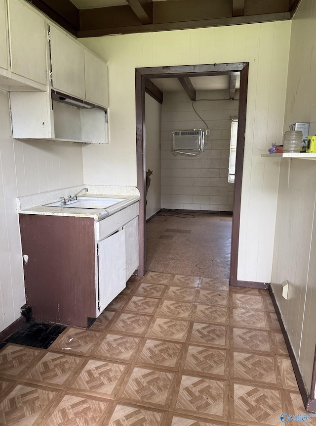 3004 SW Clopton St Unit 28, Huntsville, AL 35805 - kitchen featuring light countertops, a wall unit AC, a sink, wooden walls, and light floors