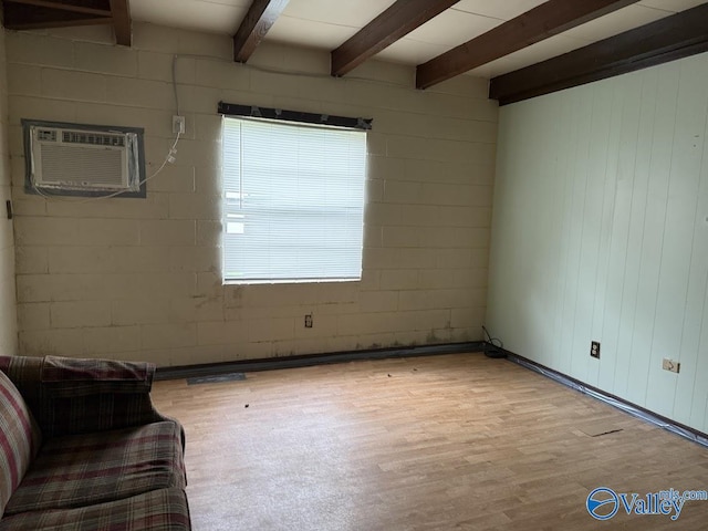 3004 SW Clopton St Unit 28, Huntsville, AL 35805 - unfurnished room with a wall unit AC, wood finished floors, beam ceiling, concrete block wall, and wood walls
