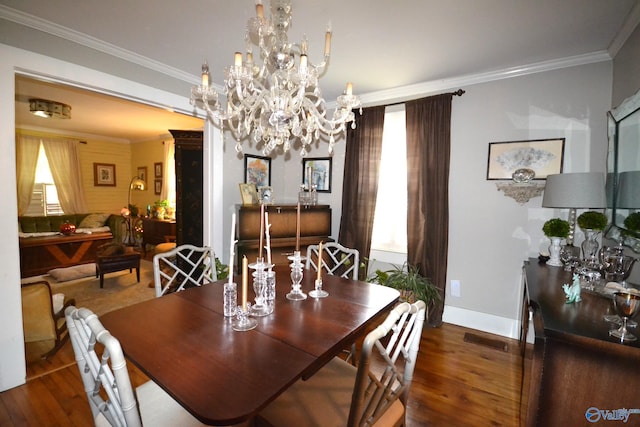 dining space featuring crown molding, dark wood-type flooring, and an inviting chandelier