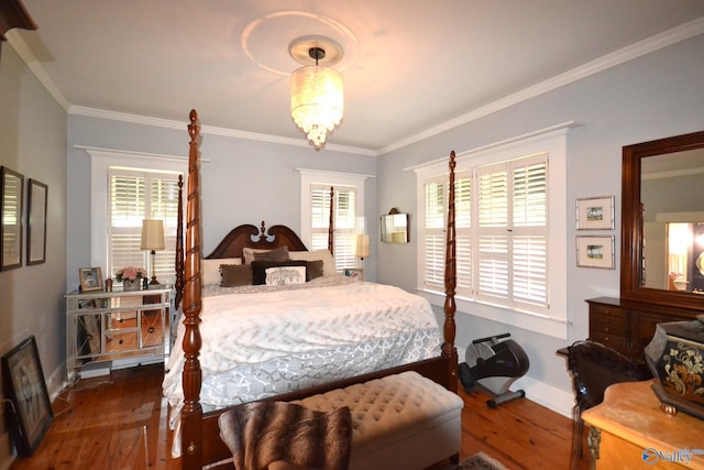 bedroom with dark wood-type flooring, crown molding, and a chandelier