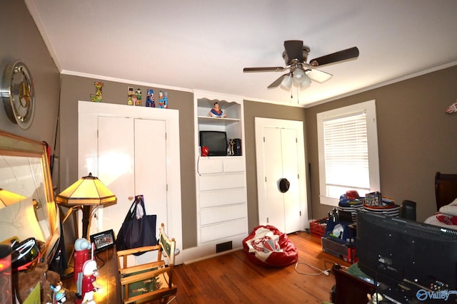 playroom featuring crown molding, ceiling fan, and wood-type flooring