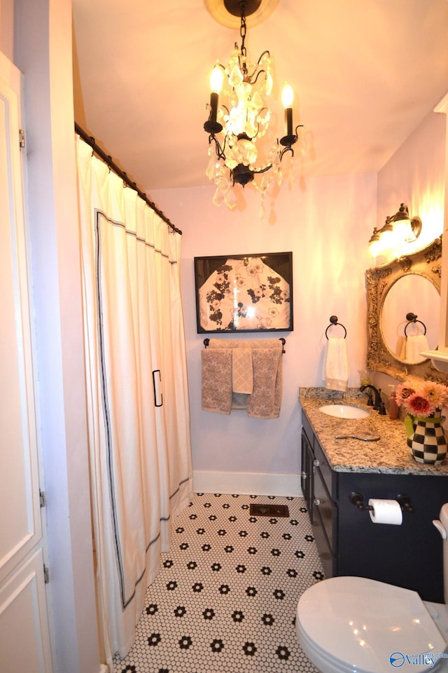 bathroom with vanity, a notable chandelier, tile patterned floors, toilet, and walk in shower