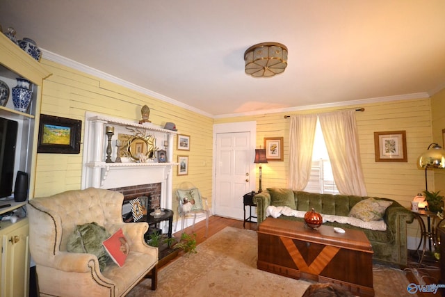 living room with a fireplace, ornamental molding, and wooden walls