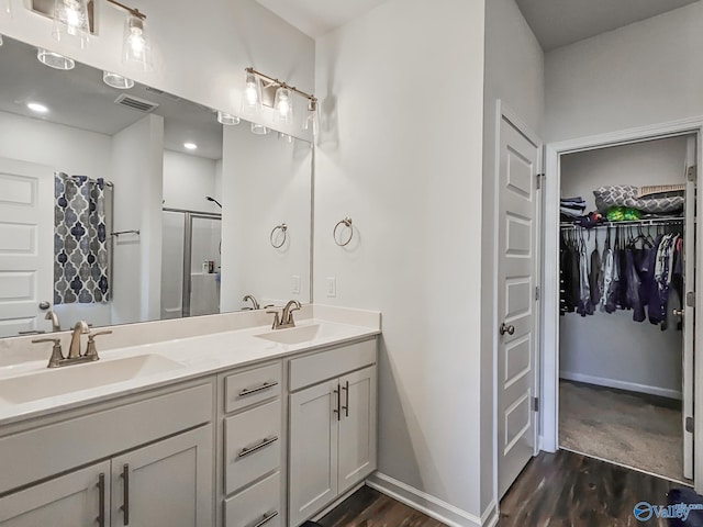 bathroom with a stall shower, visible vents, a sink, and a spacious closet