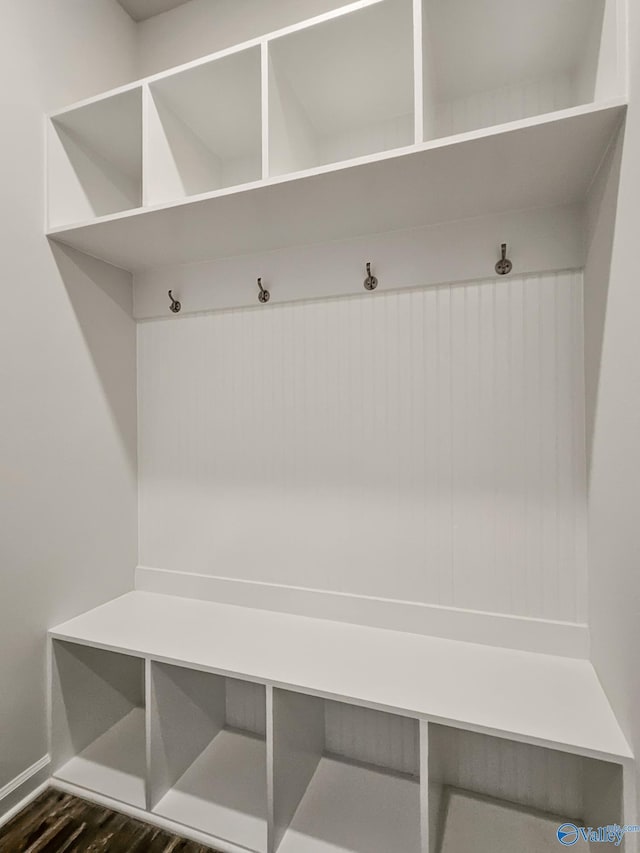 mudroom with dark wood finished floors and baseboards