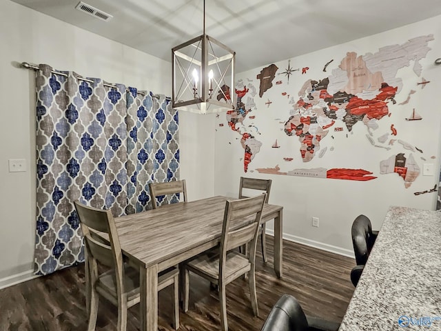 dining room with a notable chandelier, dark wood-style flooring, visible vents, and baseboards