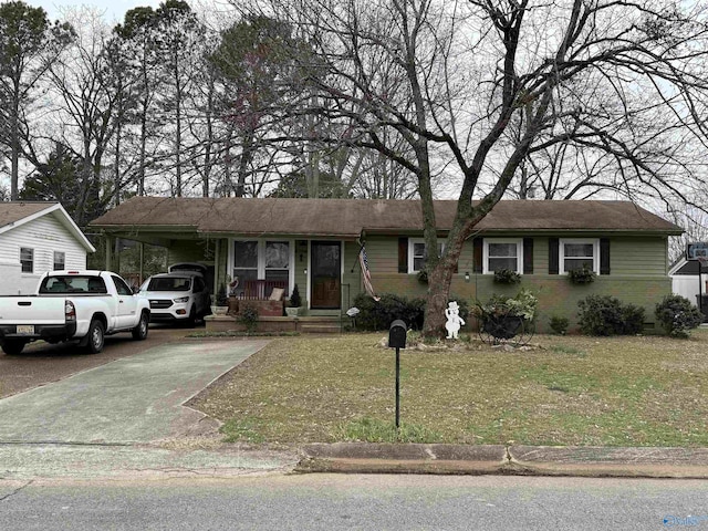 ranch-style house featuring concrete driveway, brick siding, and a front lawn