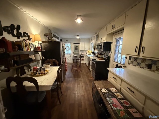 kitchen featuring dark wood finished floors, light countertops, backsplash, appliances with stainless steel finishes, and white cabinets