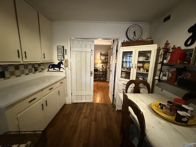 kitchen with dark wood finished floors, tasteful backsplash, light countertops, visible vents, and white cabinetry