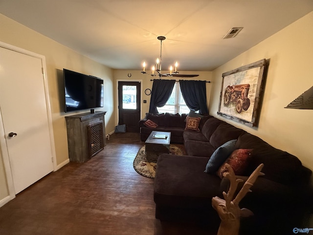 living room featuring dark wood-style floors, visible vents, and a chandelier